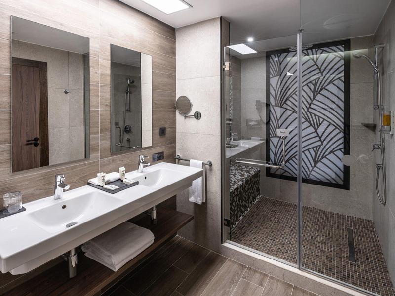 Moderne Badezimmer mit doppeltem Waschbecken und großer Glas-Dusche mit Schwarz-Weiß-Muster.