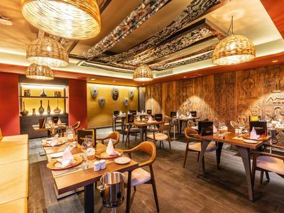 Elegantes Restaurant mit warmem Licht, Holzmöbeln und stilvollen Dekorationen für Gäste.