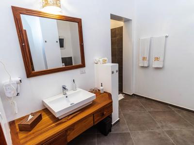 Helles Badezimmer mit großem Holzmöbel, eckigem Waschbecken und zwei weißen Handtüchern.