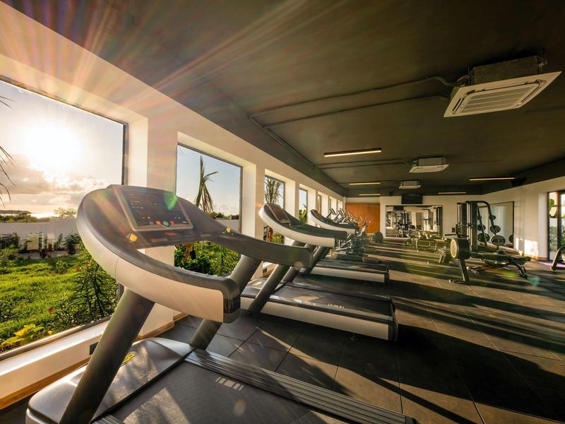 Sportschool met loopbanden bij grote ramen met zonlicht