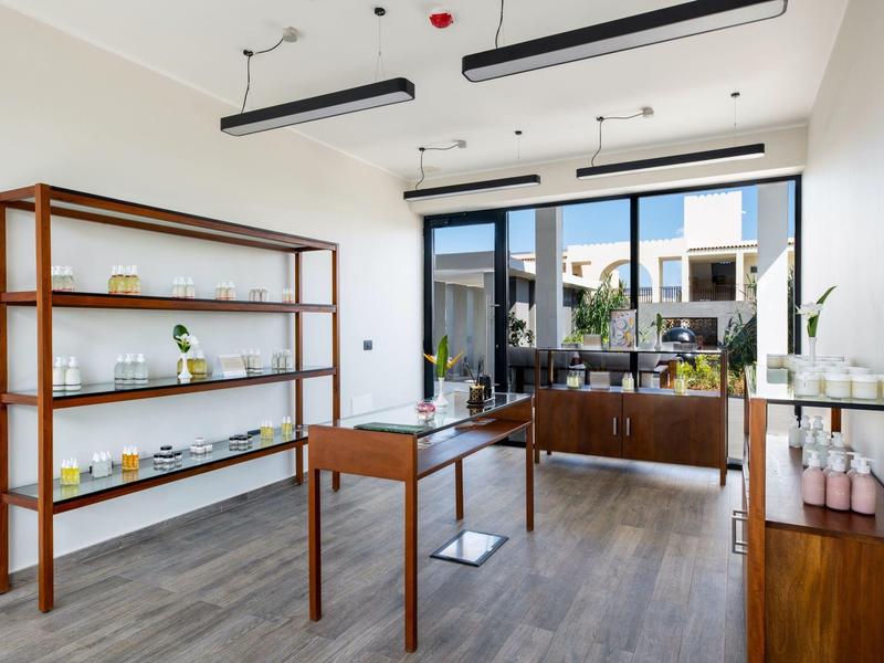 Moderne, minimalistische hotelwinkel met planken en grote ramen met uitzicht op de binnenplaats.