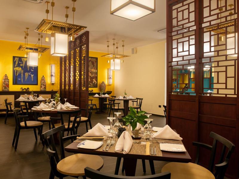 Elegant restaurant met gele muren, houten meubels en modern Aziatisch design