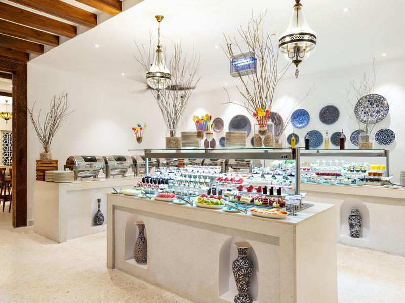 Tienda de souvenirs moderna y luminosa en hotel con vitrinas y variedad colorida de recuerdos.