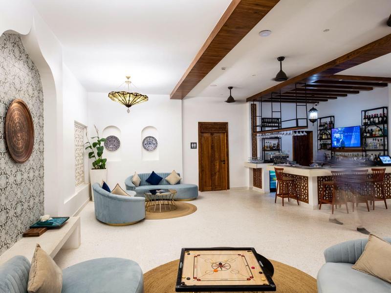 Habitación de hotel elegante con sofás, vigas de madera y área de estar moderna.