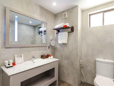 Modernes Badezimmer mit grauen Wänden, großem Spiegel, Waschbecken, Toilette und Fenster.