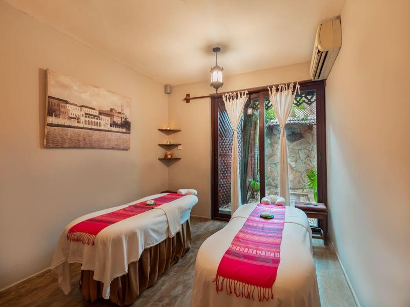 Gezellige massageruimte met twee tafels en uitzicht op een tuin.