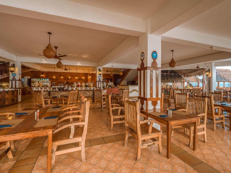 Gezellig restaurant met houten meubels en warme verlichting in een reis hotel.