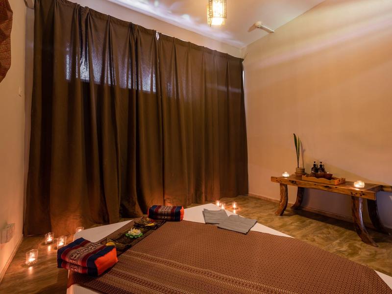 Gezellige spa-kamer met massagetafels, donkere gordijnen en zachte verlichting.