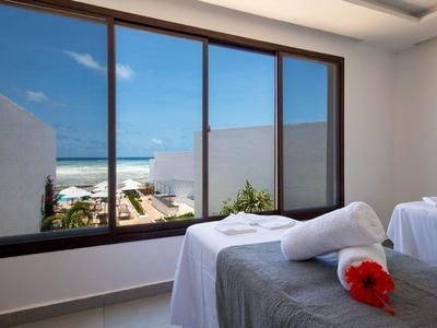 Sala massaggi luminosa con vista sul mare attraverso grandi finestre.