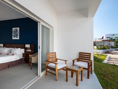 Balcone con mobili in legno accanto a porta scorrevole che conduce alla camera da letto con letto matrimoniale.