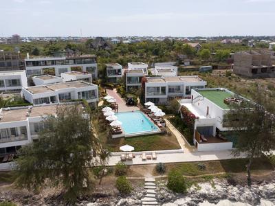 Vista di un resort moderno con più edifici e una piscina centrale