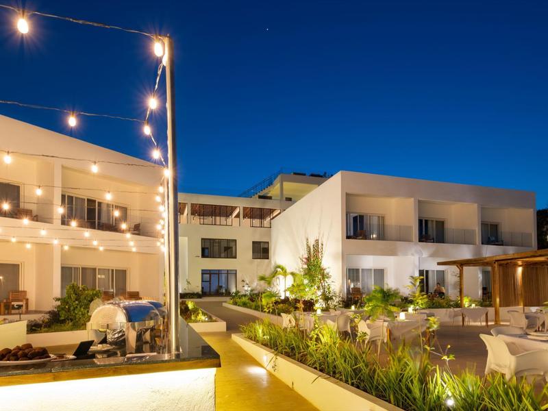 Moderno edificio dell'hotel di notte con giardino illuminato e luci a stringa