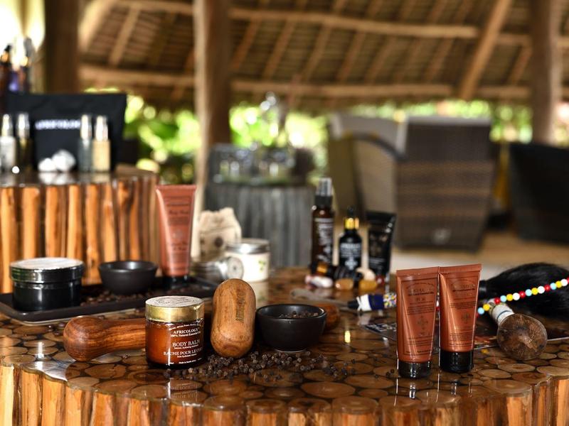 Produits de bien-être sur une table en bois dans un cadre hôtelier naturel et tropical.