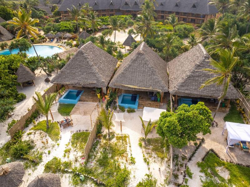 Drei Strohdach-Bungalows mit blauen Pools, umgeben von Palmen und Sandwegen am Strand.