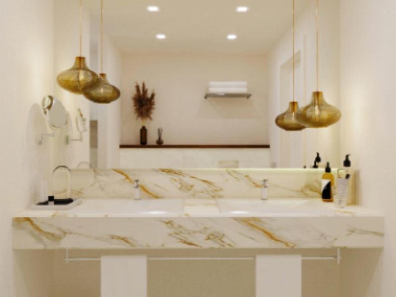Nowoczesna łazienka z marmurową umywalką i złotymi lampami wiszącymi, minimalistyczny design
