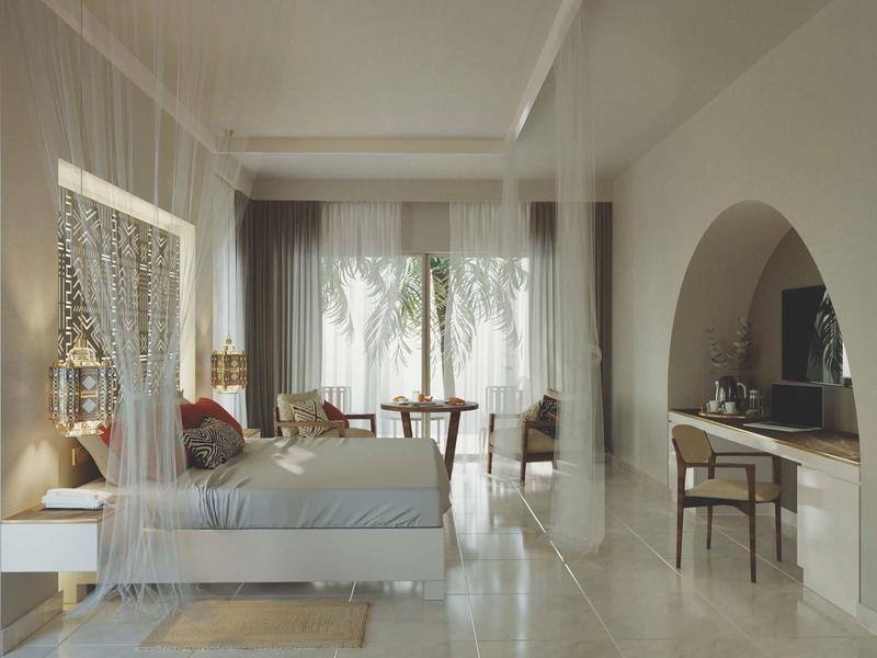 Jasny pokój hotelowy z dużym łóżkiem, miejscem do siedzenia i zasłonami na dużych oknach.