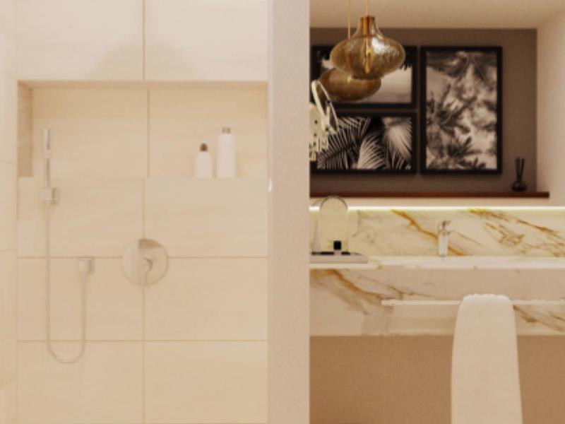 Nowoczesna beżowa łazienka z lustrem, umywalką i kabiną prysznicową w pokoju hotelowym.