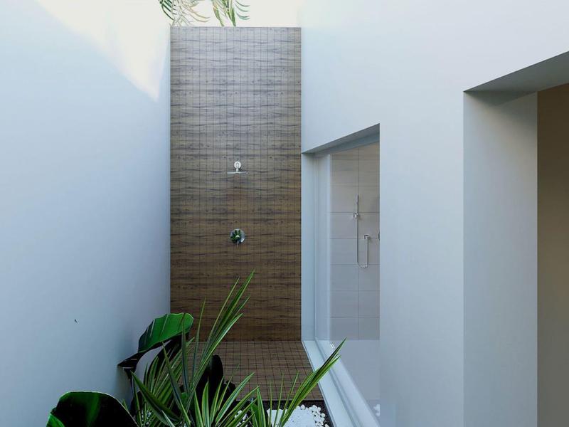 Prosta ściana zewnętrzna z zielonymi roślinami i prysznicem z kafelkami w nowoczesnym hotelu.