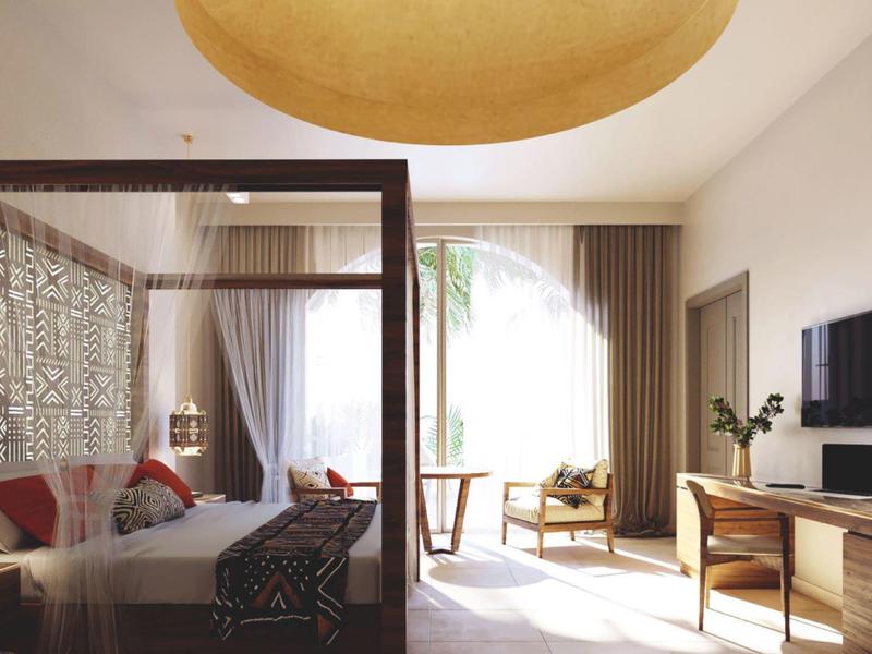 Jasny pokój hotelowy z łóżkiem z baldachimem, drewnianymi meblami i dostępem do słonecznego balkonu.