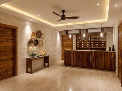 Elegante Hotellobby mit Holztheke, Deckenventilator und dekorativen Körben an der Wand.