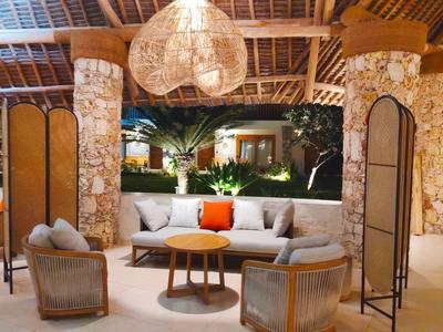 Gemütlicher Außenbereich mit Sofa, Stühlen und warmem Licht im Hotelambiente.