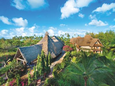 Due case rurali verdi sotto un cielo blu con nuvole.