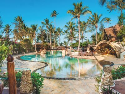Piscina all'aperto di lusso con palme e terrazza solarium sotto un cielo azzurro.
