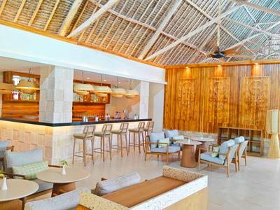 Moderne Hotel-Lounge mit Bar, Sitzbereichen und offenem Dach aus Bambus.