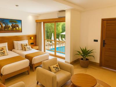 Helles Hotelzimmer mit zwei Einzelbetten, Sitzecke und Blick auf einen Pool durch große Fenster.