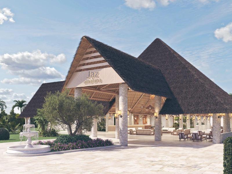 Großes Hotelgebäude mit spitzem Dach und Springbrunnen im Vorgarten