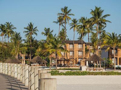 Hotel z palmami, plażą i chodnikiem w słońcu