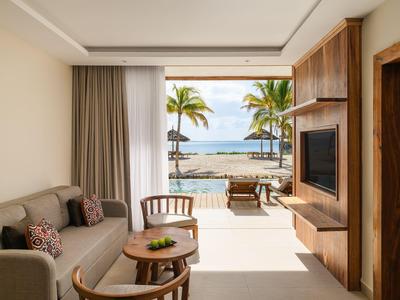 Nowoczesny pokój hotelowy z widokiem na morze i miejscem do siedzenia na balkonie.