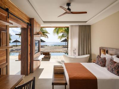 Elegancki pokój hotelowy z łóżkiem king-size, widokiem na morze i prywatnym basenem na tarasie.