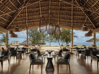 Otwarta zadaszona jadalnia z widokiem na piaszczystą plażę i morze