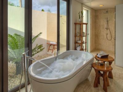 Modernes Badezimmer mit freistehender Badewanne, Glasfenstern und natürlichem Licht.