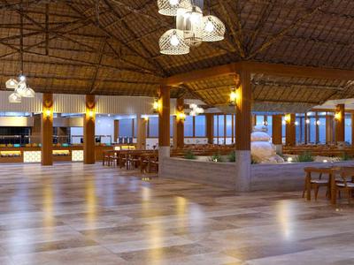 Großer, offener Speisesaal mit Holzmöbeln und dekorativer Decke in einem Resort