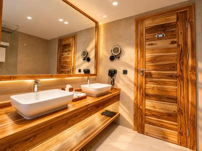 Salle de bain d'hôtel moderne avec accents en bois, deux éviers blancs et un grand miroir.