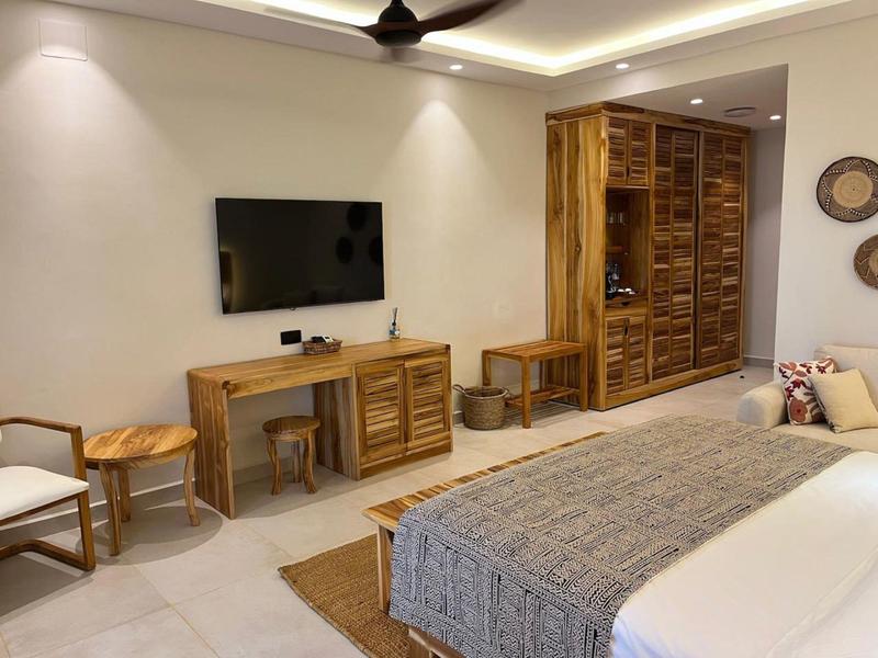 Modernes Schlafzimmer mit Holzmöbeln, Bett, Schrank, Schreibtisch und Deckenventilator.