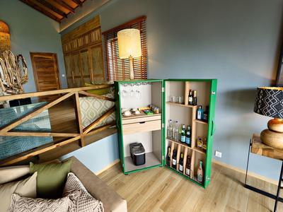 Moderní barový kout s otevřenými policemi, lahvemi a jemným osvětlením v elegantním pokoji.