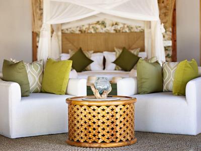 Elegantní lounge kout s bílou pohovkou a dřevěným stolkem v hotelovém pokoji.