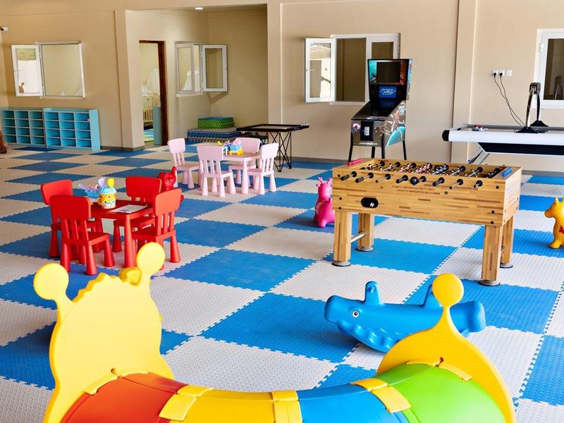 Dětská herna s barevnými hračkami a herními stoly v hotelu.