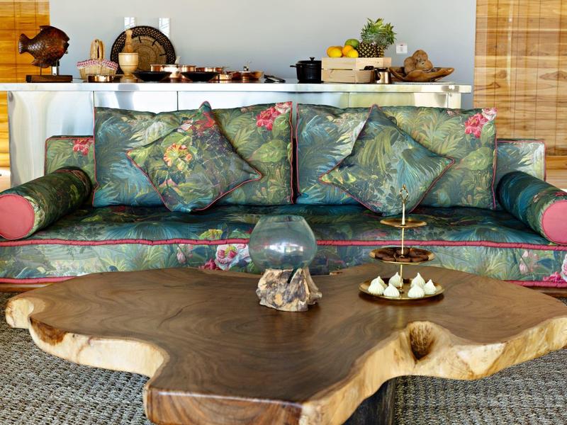 Barevná pohovka se dřevěným konferenčním stolkem v útulném obývacím pokoji.