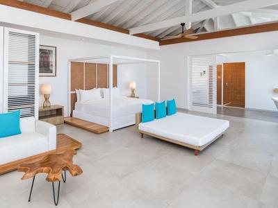Bright, modern hotel room with canopy bed, wooden accents, and blue pillows.