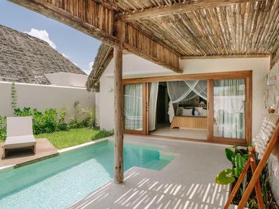 Überdachte Terrasse mit Pool und Blick auf ein modernes Schlafzimmer in einem Urlaubsdomizil.