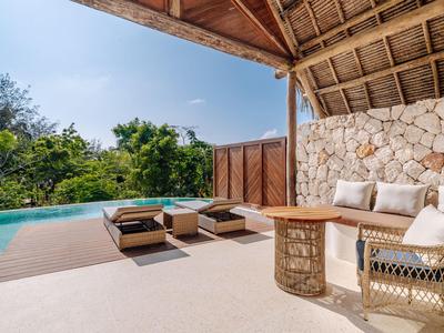 Moderner Außenbereich mit Pool, Sitzgelegenheiten und Steinwand unter Holzüberdachung