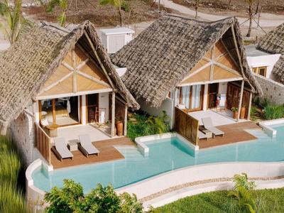 Zwei bungalows mit strohgedeckten Dächern und privaten pools in tropischer Umgebung.