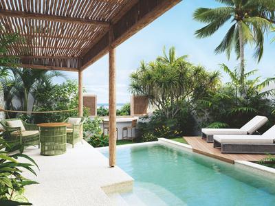 Terraza de piscina lujosa con tumbonas y vegetación tropical bajo un techo de madera.