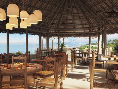 Offener Restaurantbereich mit Holzmöbeln, Strohdach und Meerblick im Hintergrund.