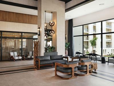 Espace de hall d'hôtel moderne avec sièges confortables et grandes fenêtres.