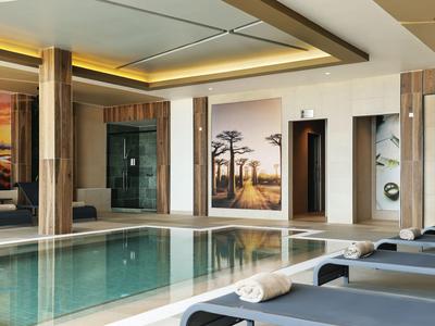 Piscine intérieure moderne avec chaises longues et tableau mural dans un hôtel